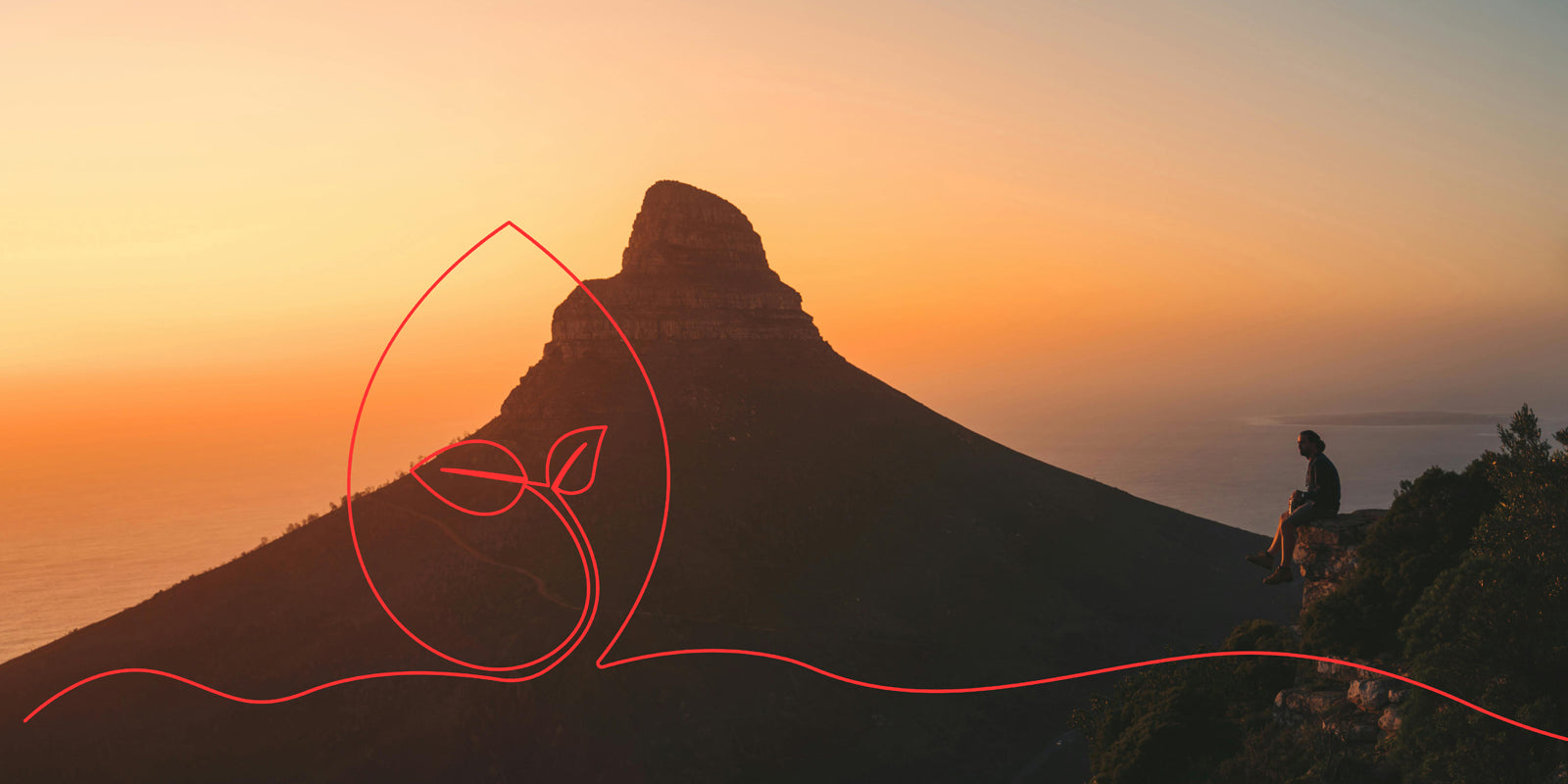 A man sitting and watching Lion’s Head mountain at sunset, with the sky glowing in warm orange and pink hues. There is an orange graphic element of a line overlaying the image from left to right.