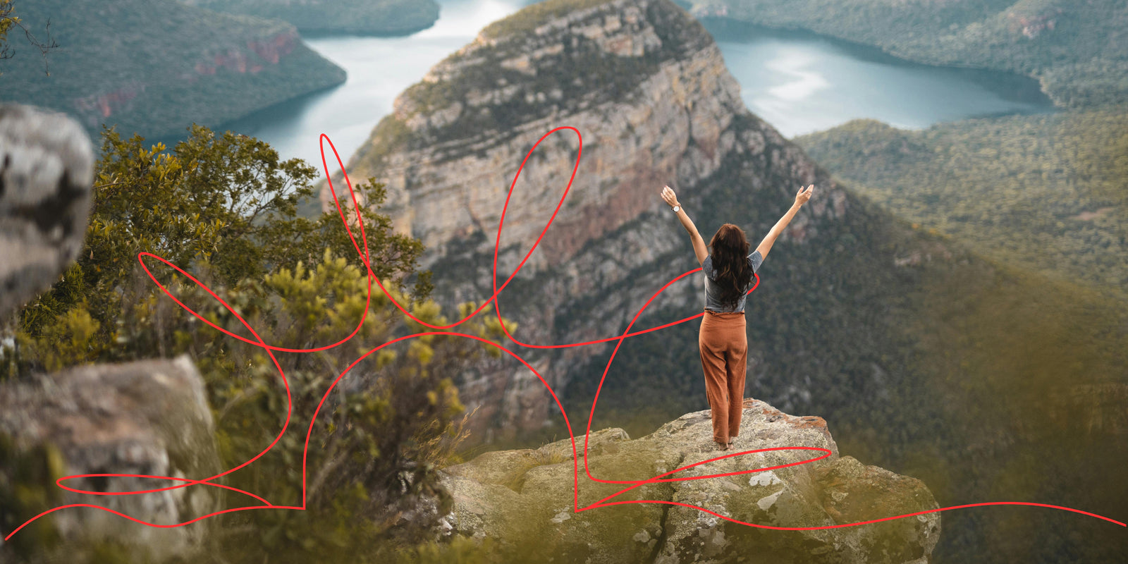 A woman standing with her arms raised, overlooking a lush green canyon filled with trees and vegetation. There is an orange graphic element of a line overlaying the image from left to right.