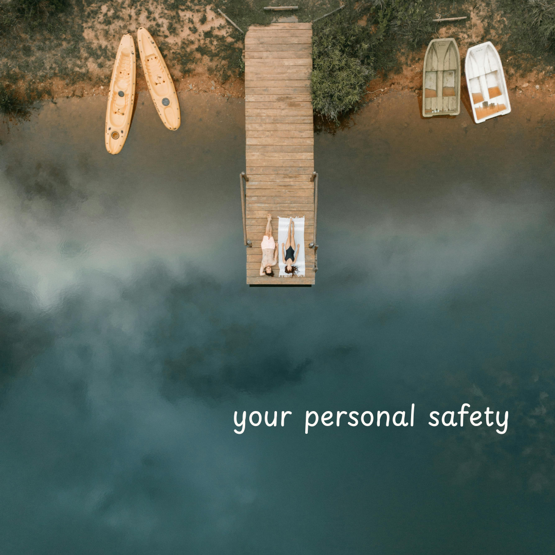 A birds eye view of a dock with canoes on either side and two people laying on the dock. There is white text that says, "Your personal safety".